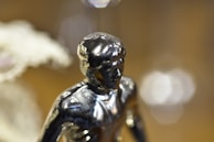 Close-up of a metallic gold figure with smooth curves reflecting ambient light.