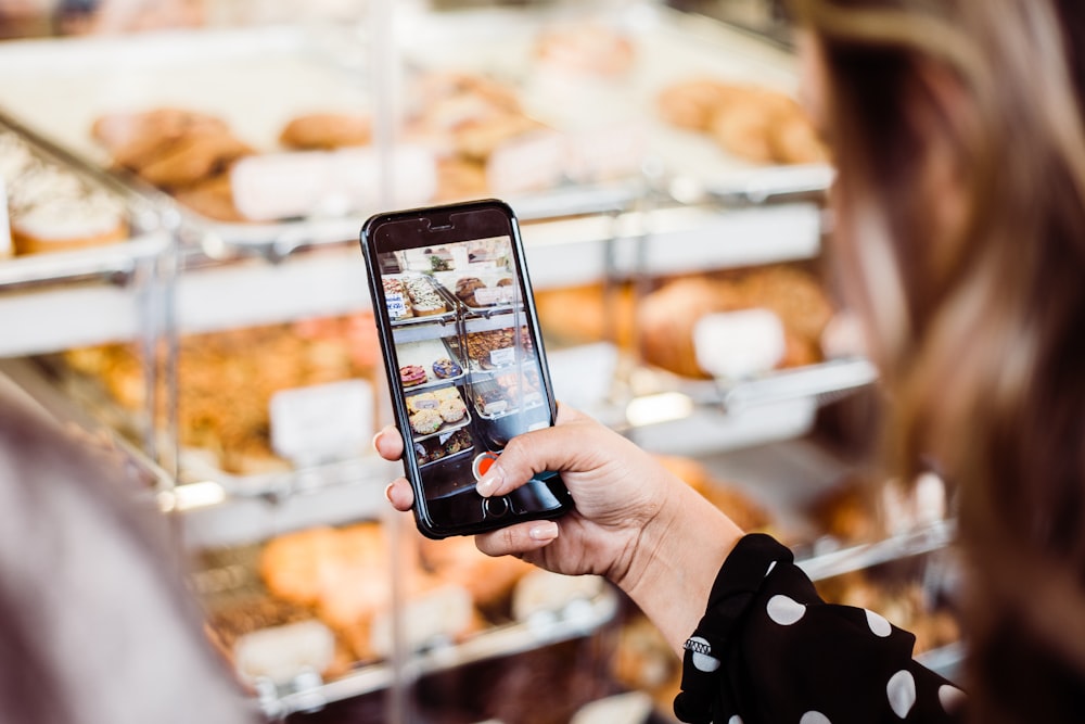 mujer que toma foto exhibición de alimentos