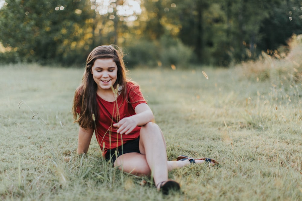 selective focus photo of woman sitting on the grass