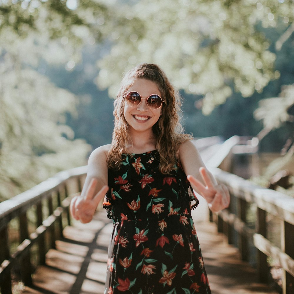 woman standing on wooden bridge