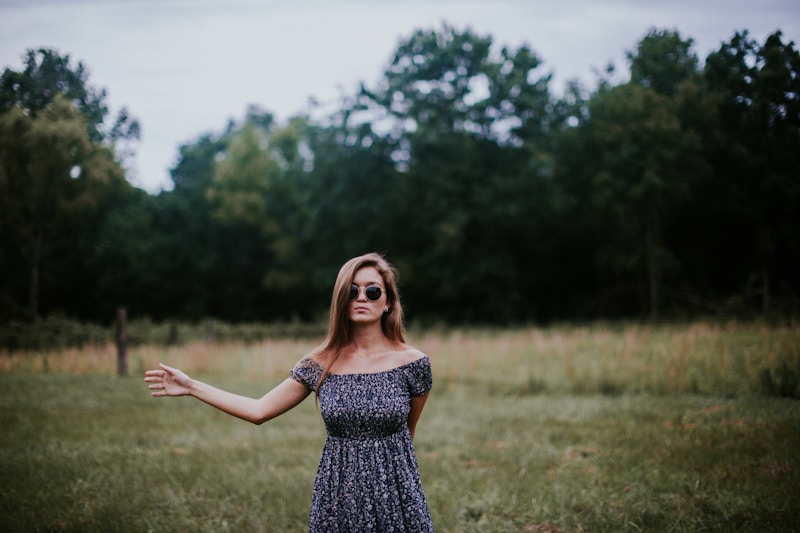 selective focus photo of woman standing on grass field
