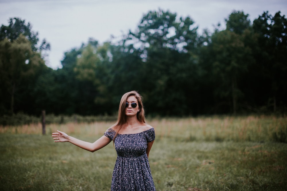 selective focus photo of woman standing on grass field