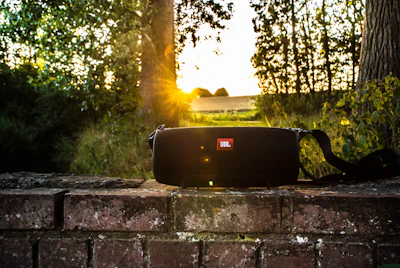 black JBL portable speaker on brick bench