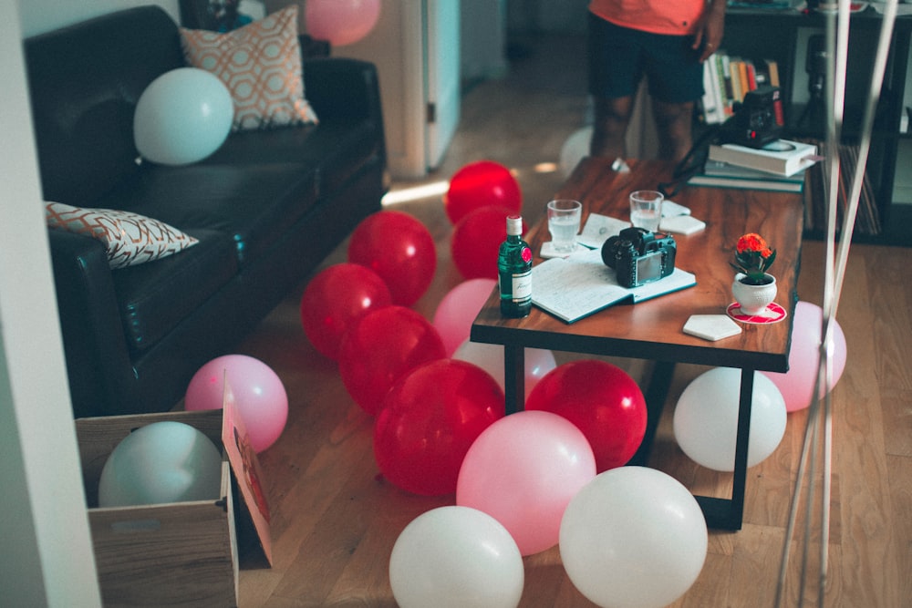 Red, pink and white balloons on the floor in a living room in Toronto, ahead of a house party