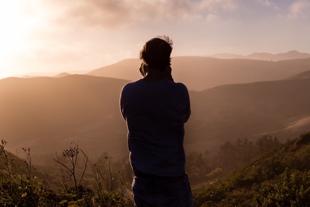 person shouting on top of mountain