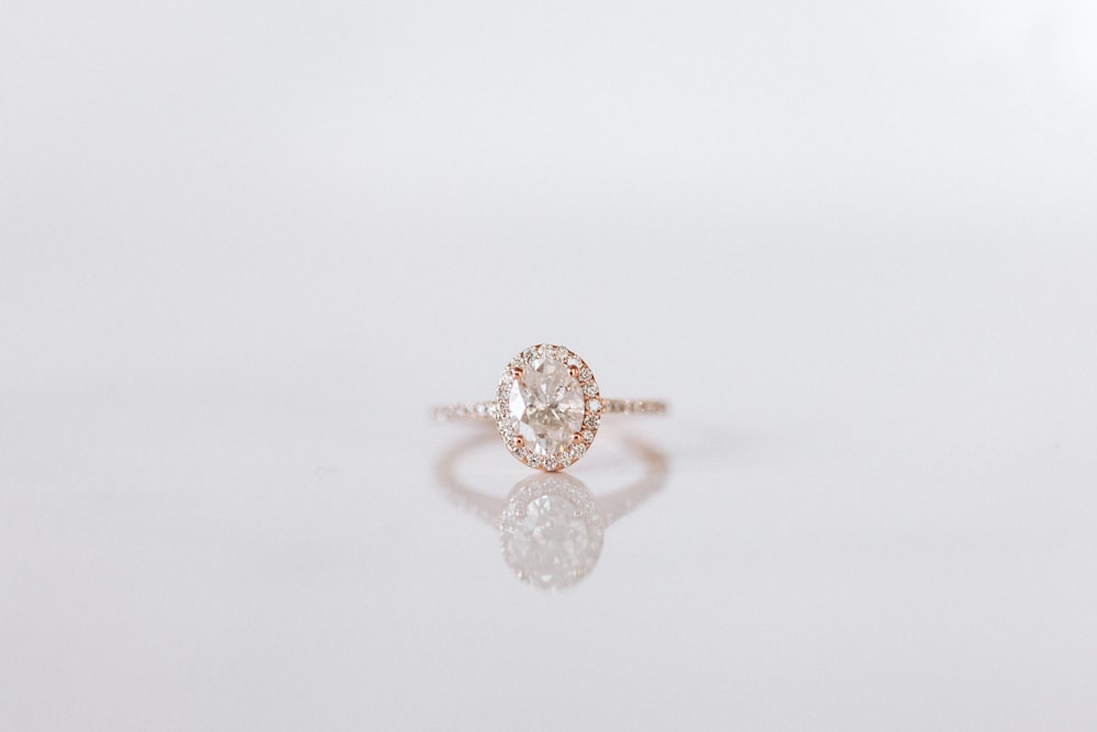 silver diamond studded ring on white surface