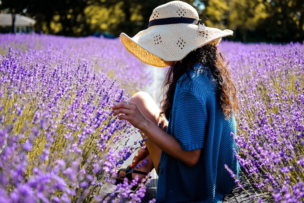 昼間に撮影した紫色のラベンダー畑で挟まれた女性