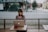 woman in gray shirt sitting on bench in front of MacBook