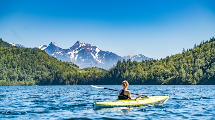 woman kayaking on lake during daytime