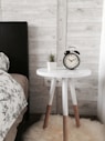black alarm clock at 10:10 on white wooden table near table