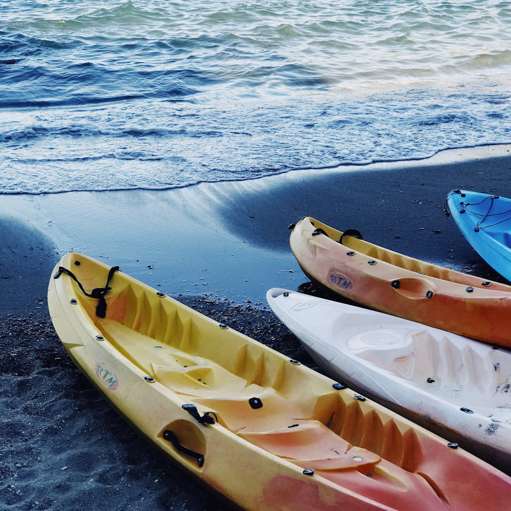 Quatre kayaks de couleurs assorties au bord de la mer