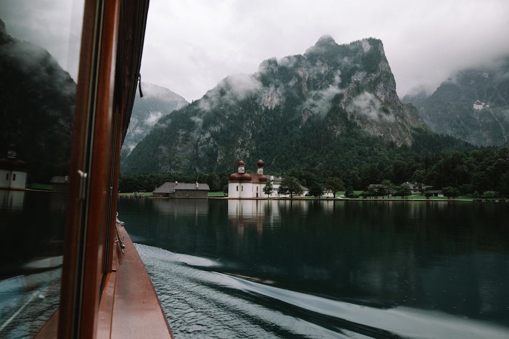 brown wooden boat on body of water in front of mountain photo