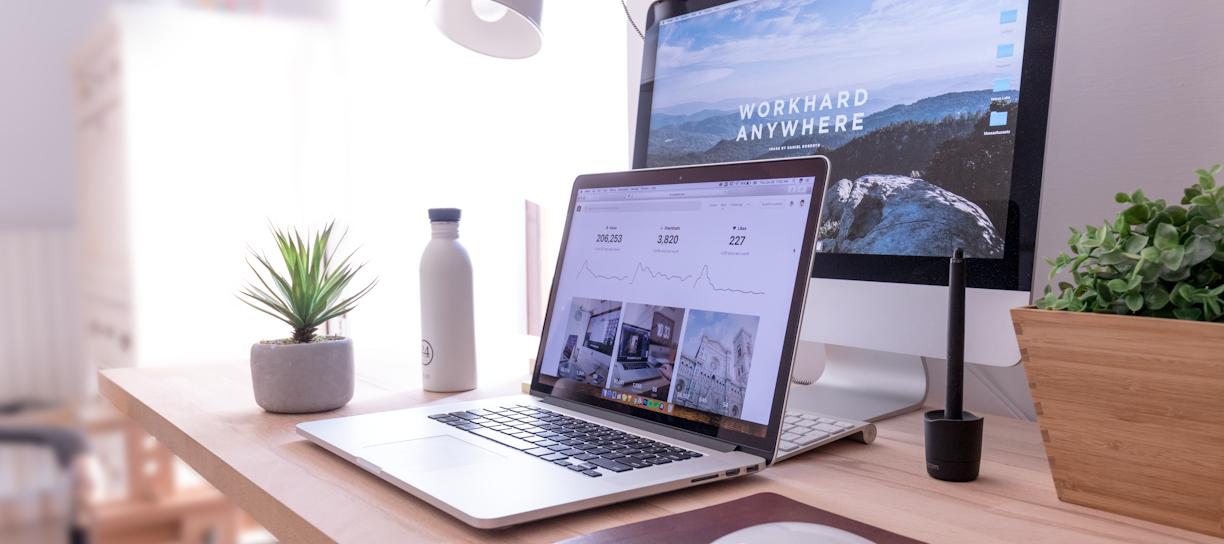 MacBook Pro on table beside white iMac and Magic Mouse