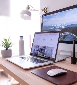 MacBook Pro on table beside white iMac and Magic Mouse