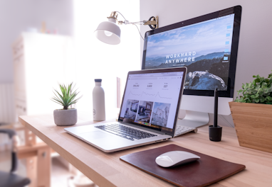 MacBook Pro on table beside white iMac and Magic Mouse