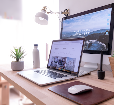 MacBook Pro on table beside white iMac and Magic Mouse