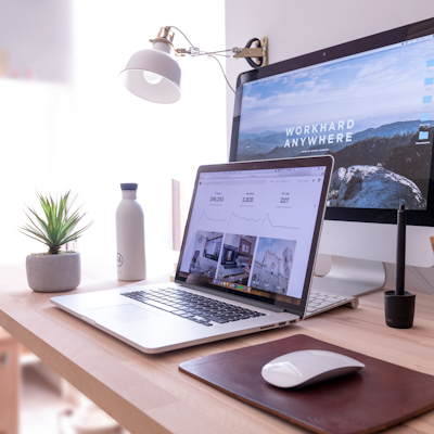 MacBook Pro on table beside white iMac and Magic Mouse