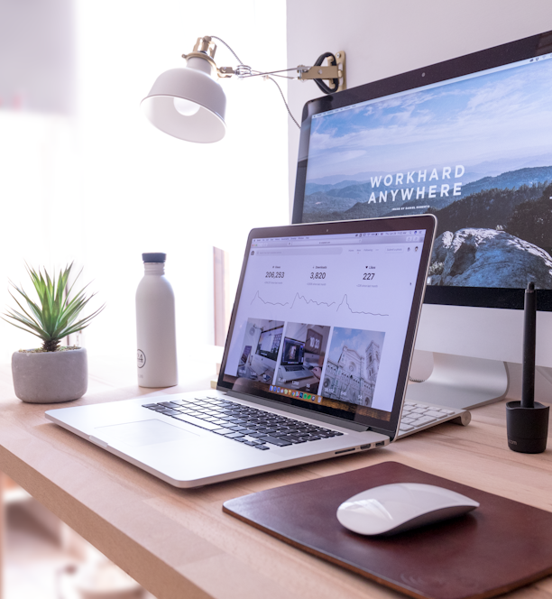 MacBook Pro on table beside white iMac and Magic Mouse