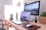 MacBook Pro on table beside white iMac and Magic Mouse