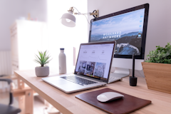 MacBook Pro on table beside white iMac and Magic Mouse