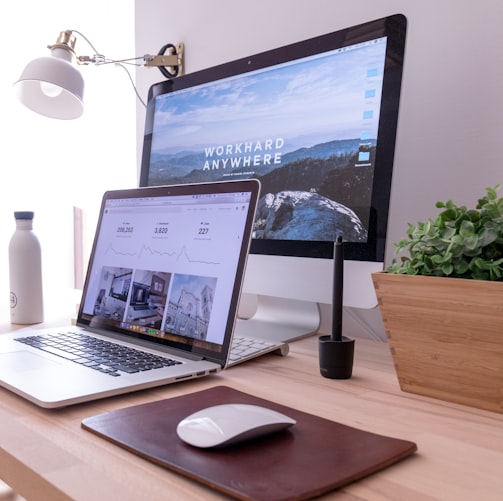 MacBook Pro on table beside white iMac and Magic Mouse