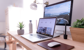 MacBook Pro on table beside white iMac and Magic Mouse