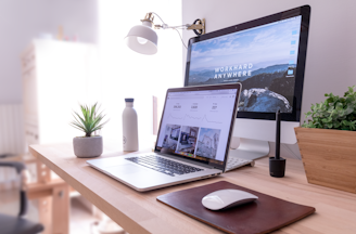 MacBook Pro on table beside white iMac and Magic Mouse