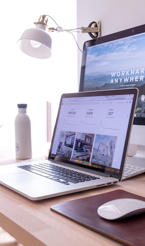 MacBook Pro on table beside white iMac and Magic Mouse