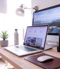 MacBook Pro on table beside white iMac and Magic Mouse