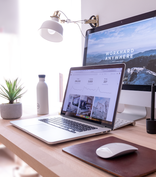 MacBook Pro on table beside white iMac and Magic Mouse