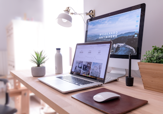 MacBook Pro on table beside white iMac and Magic Mouse