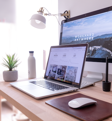 MacBook Pro on table beside white iMac and Magic Mouse