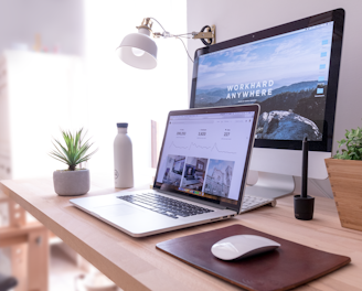 MacBook Pro on table beside white iMac and Magic Mouse