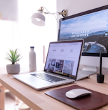 MacBook Pro on table beside white iMac and Magic Mouse