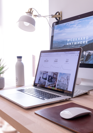 MacBook Pro on table beside white iMac and Magic Mouse