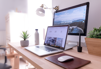 MacBook Pro on table beside white iMac and Magic Mouse