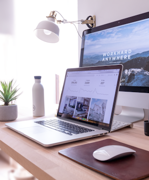 MacBook Pro on table beside white iMac and Magic Mouse