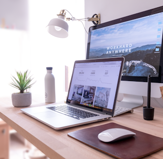 MacBook Pro on table beside white iMac and Magic Mouse