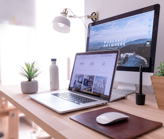 MacBook Pro on table beside white iMac and Magic Mouse