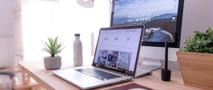 MacBook Pro on table beside white iMac and Magic Mouse