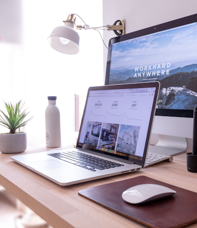 MacBook Pro on table beside white iMac and Magic Mouse