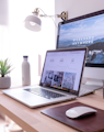 MacBook Pro on table beside white iMac and Magic Mouse