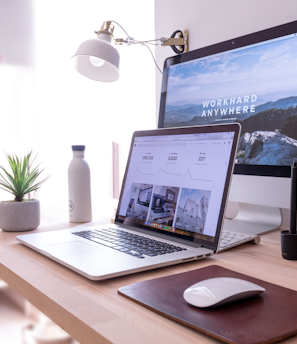 MacBook Pro on table beside white iMac and Magic Mouse