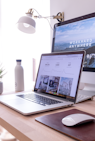 MacBook Pro on table beside white iMac and Magic Mouse