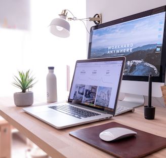 MacBook Pro on table beside white iMac and Magic Mouse