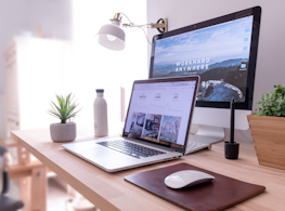 MacBook Pro on table beside white iMac and Magic Mouse