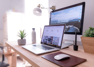 MacBook Pro on table beside white iMac and Magic Mouse