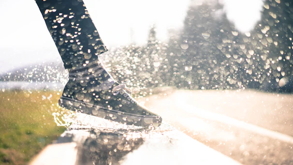 A person stepping out of the shower wearing slipara slippers, water droplets visible on the floor.