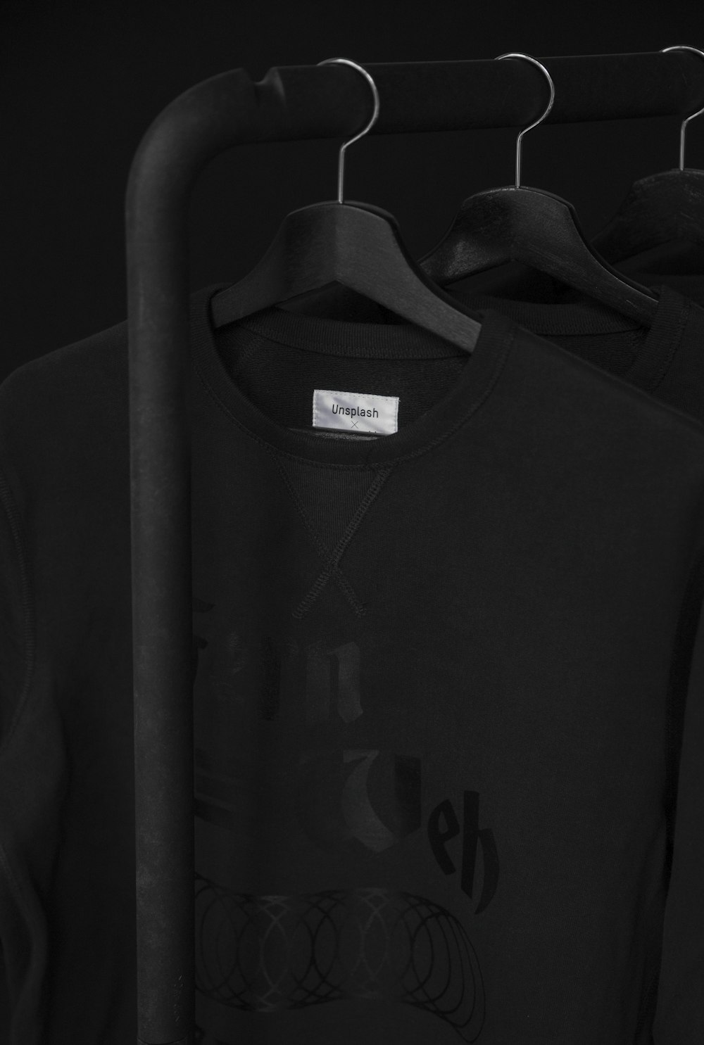 schwarzes T-Shirt mit Rundhalsausschnitt auf Kleiderbügel