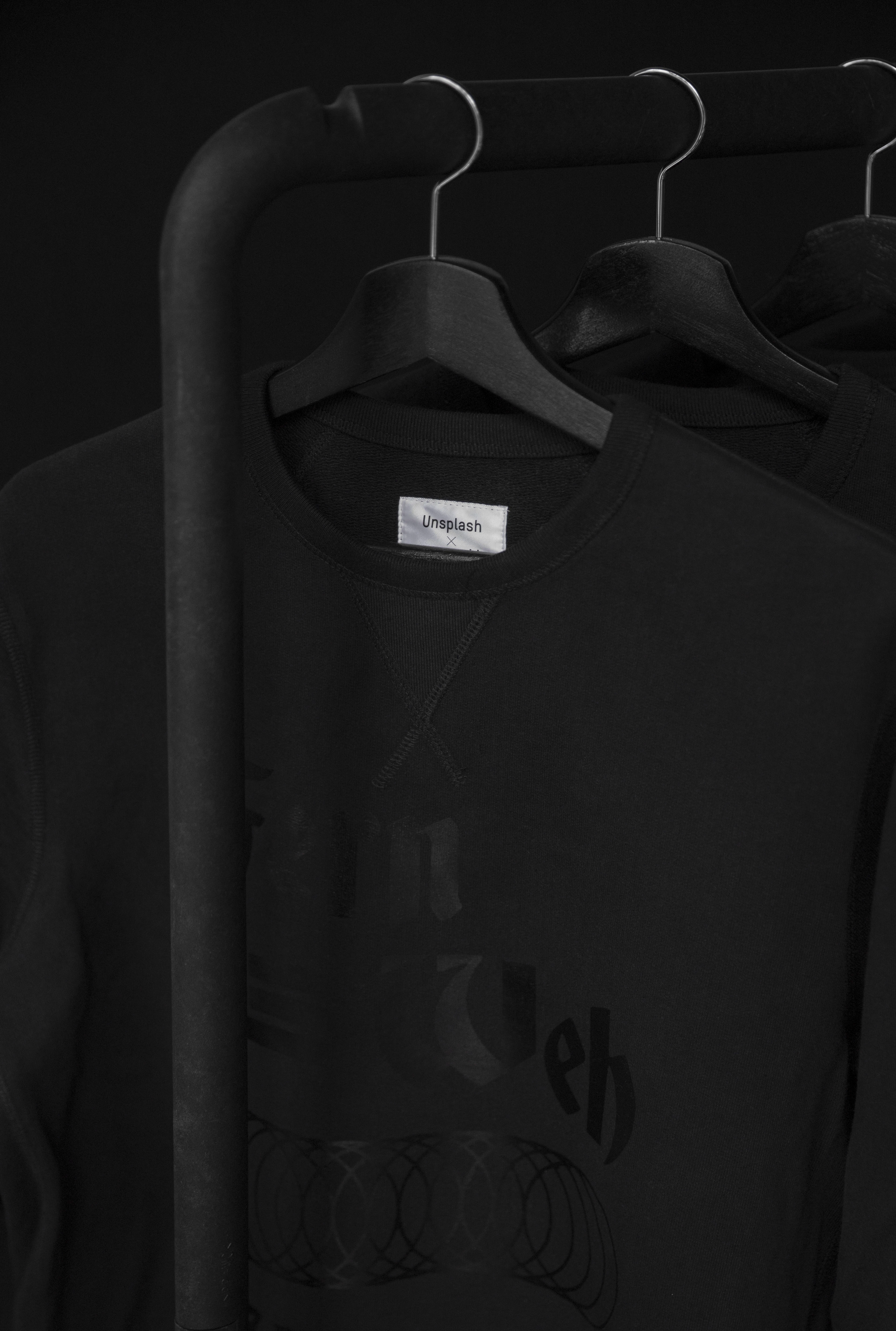 Camiseta preta de gola careca pendurada em uma arara